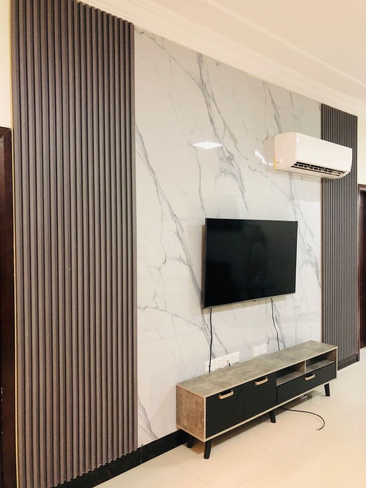 TV Wall Application Glossy marble-effect UV sheet combined with dark fluted wall panels by Home Plus Materials